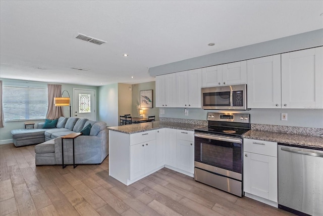 kitchen featuring white cabinets, stainless steel appliances, and light hardwood / wood-style floors