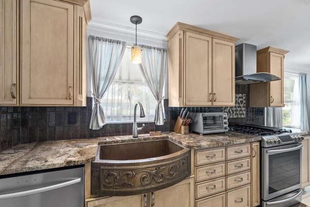 kitchen with sink, wall chimney exhaust hood, tasteful backsplash, dark stone counters, and appliances with stainless steel finishes