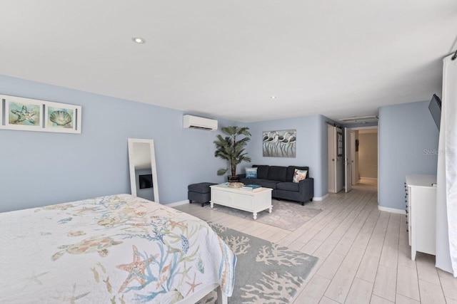 bedroom with light hardwood / wood-style floors and a wall mounted air conditioner