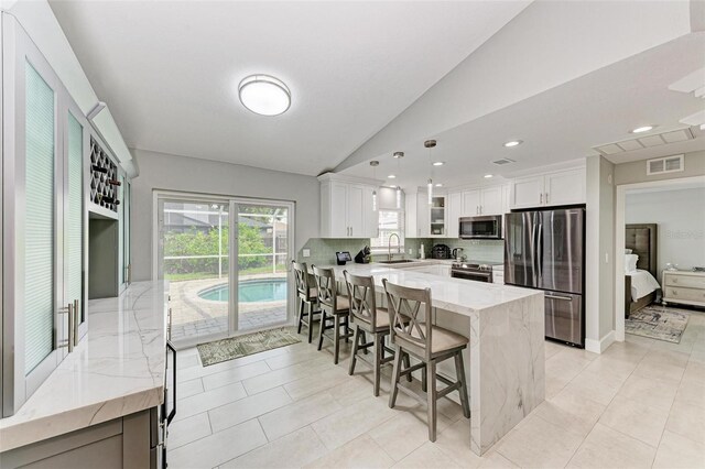 kitchen with white cabinets, pendant lighting, stainless steel appliances, and sink