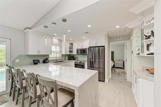 kitchen with kitchen peninsula, white cabinetry, pendant lighting, and stainless steel appliances