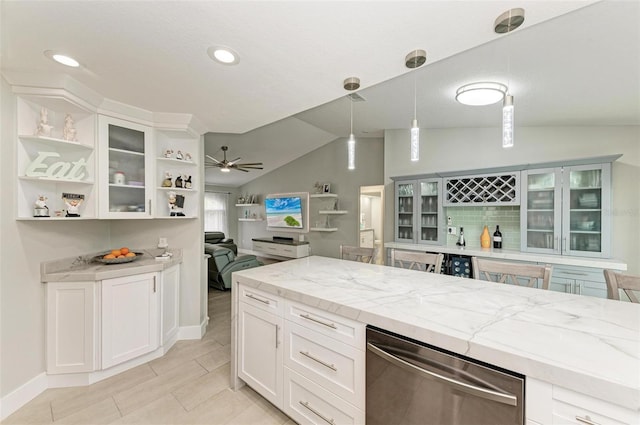 kitchen with light stone countertops, ceiling fan, hanging light fixtures, lofted ceiling, and white cabinets