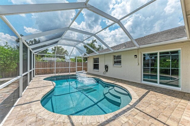 view of swimming pool with a lanai and a patio area