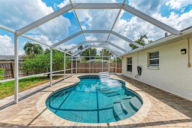 view of swimming pool featuring a lanai and a patio