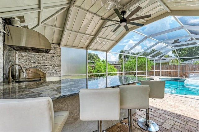 view of pool with glass enclosure, a patio area, and sink