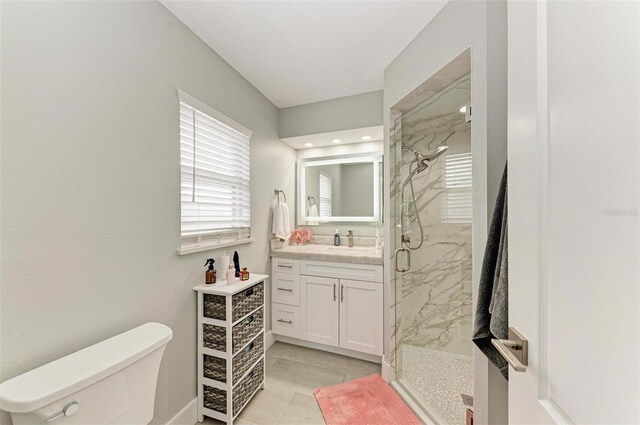 bathroom featuring tile patterned floors, vanity, toilet, and a shower with door