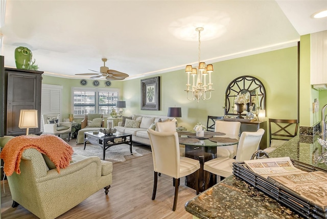 dining room featuring crown molding, ceiling fan with notable chandelier, and hardwood / wood-style flooring