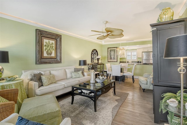 living room with ceiling fan, hardwood / wood-style flooring, and crown molding