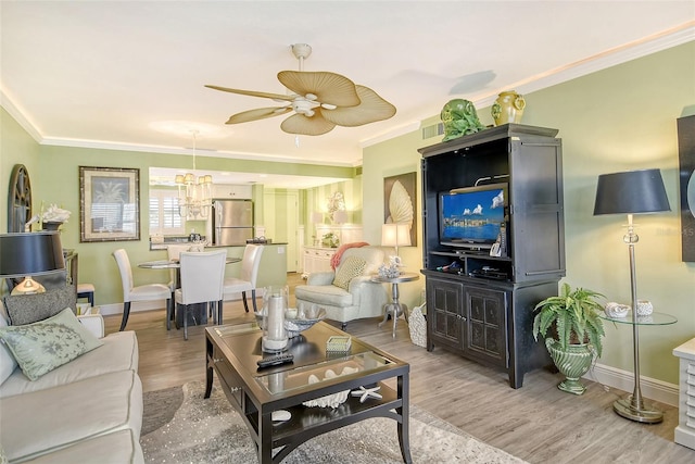 living room with ceiling fan with notable chandelier, hardwood / wood-style flooring, and ornamental molding