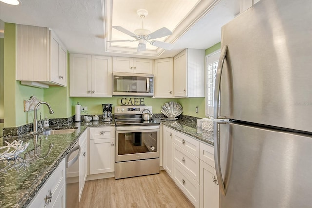 kitchen featuring light hardwood / wood-style flooring, stainless steel appliances, sink, white cabinetry, and ceiling fan