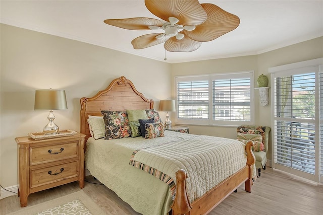 bedroom featuring ceiling fan, crown molding, and wood-type flooring