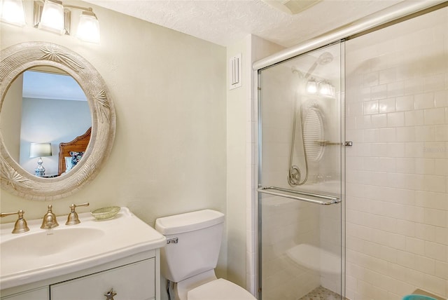 bathroom with a shower with door, vanity, toilet, and a textured ceiling