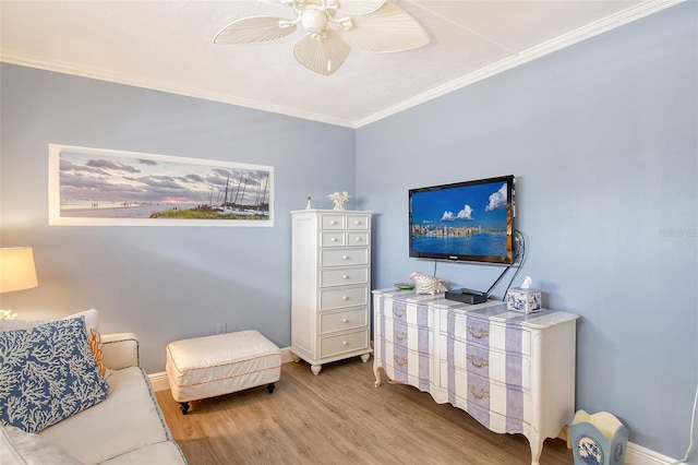 interior space featuring light wood-type flooring, ceiling fan, and ornamental molding