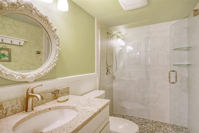 bathroom with walk in shower, toilet, and vanity