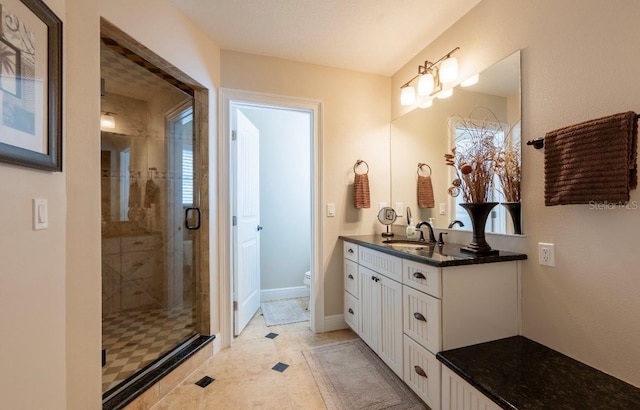 bathroom with tile patterned floors, vanity, toilet, and a shower with door