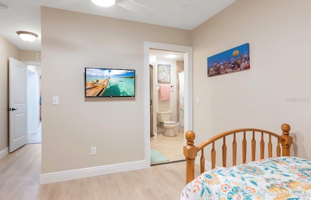 bedroom featuring ceiling fan, light hardwood / wood-style floors, and connected bathroom