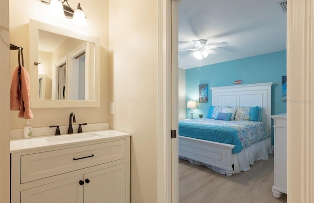 bedroom featuring ceiling fan, light hardwood / wood-style floors, and sink