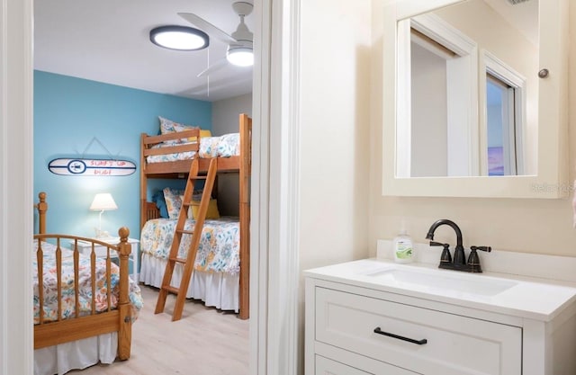 interior space with ensuite bath, a ceiling fan, wood finished floors, and vanity