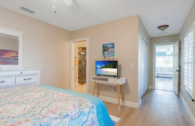 bedroom with ceiling fan, light wood-type flooring, and connected bathroom