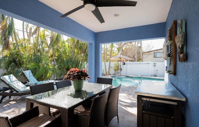 view of patio with a fenced backyard, a fenced in pool, outdoor dining area, and a ceiling fan