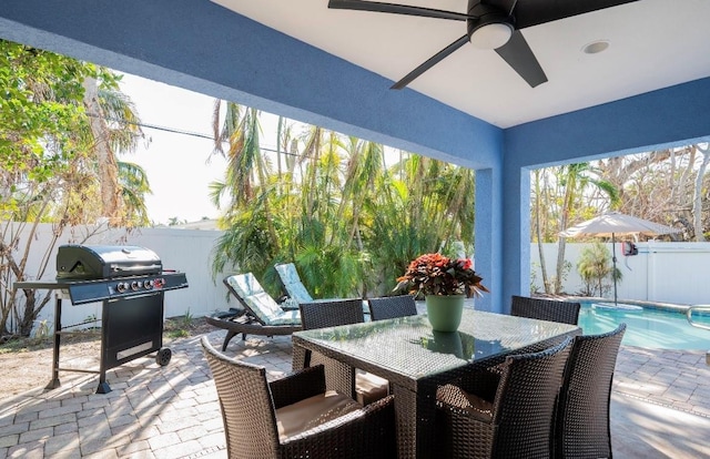 view of patio featuring a fenced in pool, outdoor dining area, grilling area, ceiling fan, and a fenced backyard