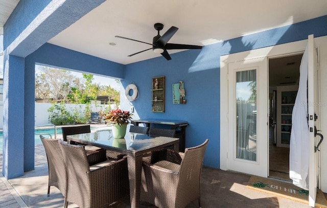 view of patio featuring ceiling fan, fence, outdoor dining area, and a fenced in pool