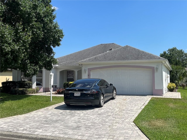 single story home with a garage and a front lawn