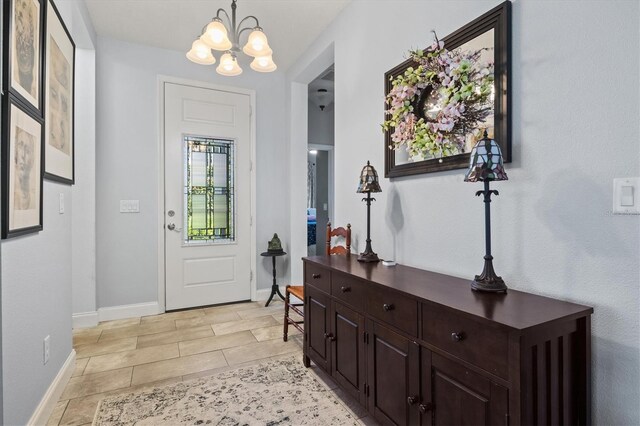 tiled foyer featuring an inviting chandelier