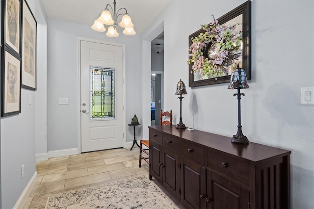 foyer with an inviting chandelier and baseboards