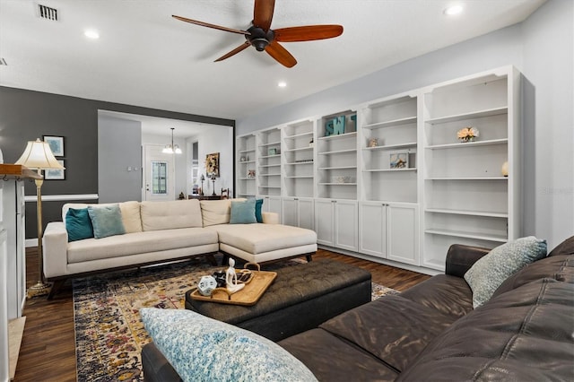 living room featuring dark wood-type flooring, recessed lighting, visible vents, and ceiling fan with notable chandelier