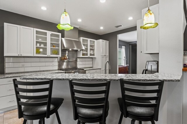 kitchen featuring white cabinets, backsplash, and light stone countertops