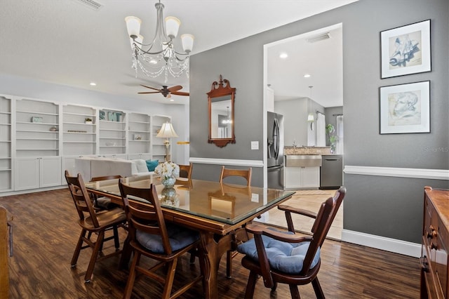 dining space featuring ceiling fan with notable chandelier and dark hardwood / wood-style floors