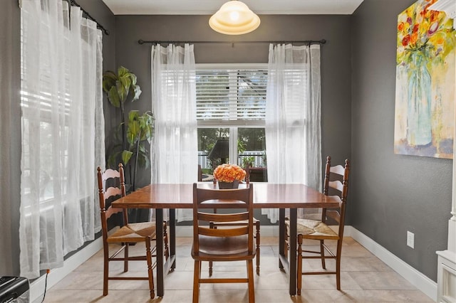 dining space featuring light tile patterned floors and baseboards