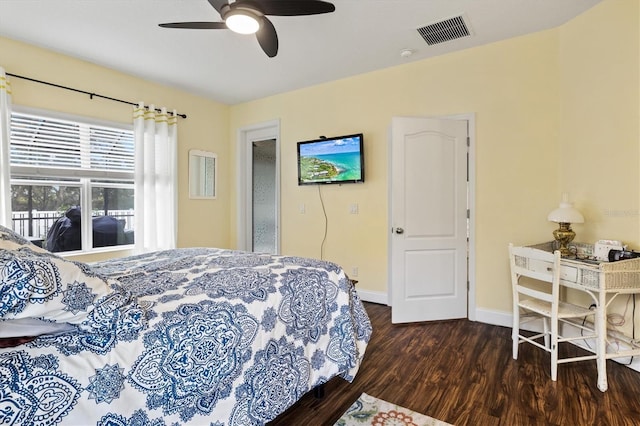 bedroom with a ceiling fan, dark wood-style flooring, visible vents, and baseboards