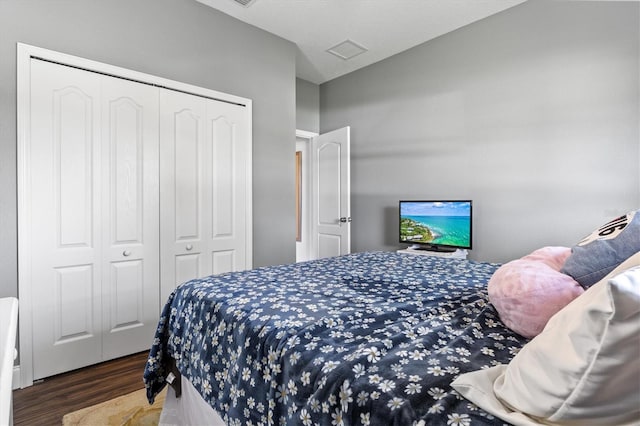 bedroom featuring vaulted ceiling, dark wood-type flooring, a closet, and visible vents