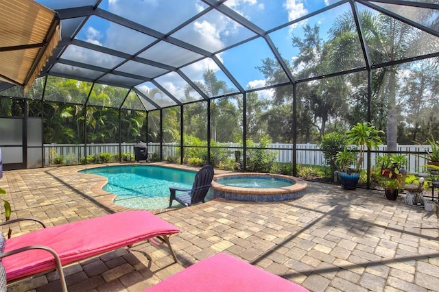 view of pool featuring glass enclosure, a fenced backyard, a pool with connected hot tub, and a patio