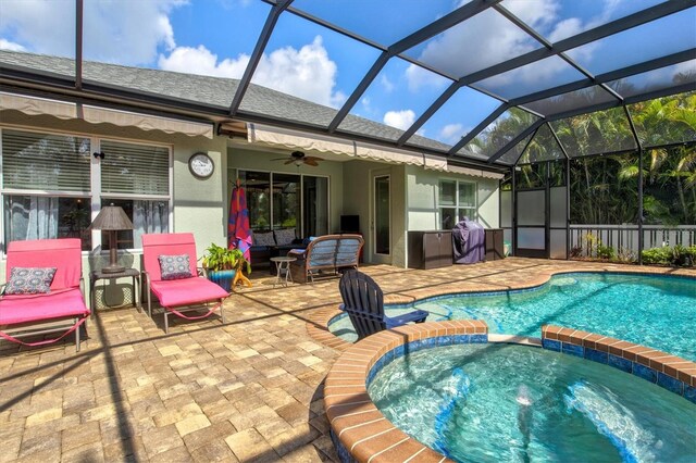 view of pool featuring a lanai, an in ground hot tub, a patio area, and ceiling fan