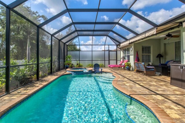 view of pool featuring a patio area, an in ground hot tub, a lanai, and ceiling fan