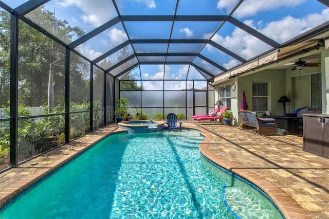 view of pool featuring glass enclosure, ceiling fan, an outdoor hangout area, a patio area, and a pool with connected hot tub