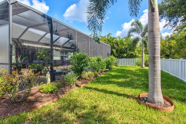 view of yard with glass enclosure and a fenced backyard