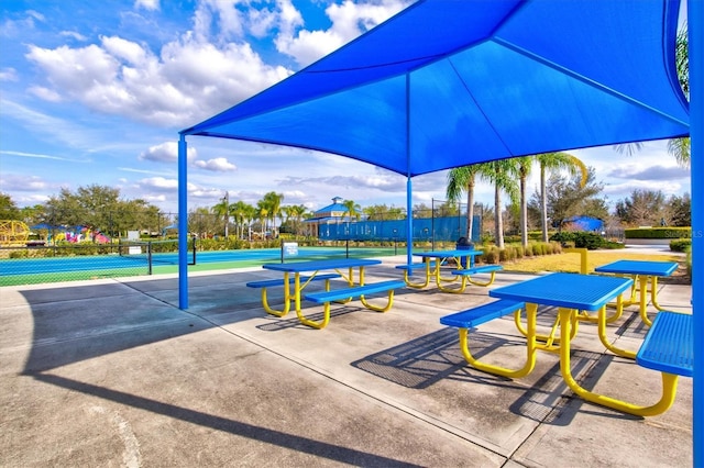 exterior space featuring a tennis court and fence