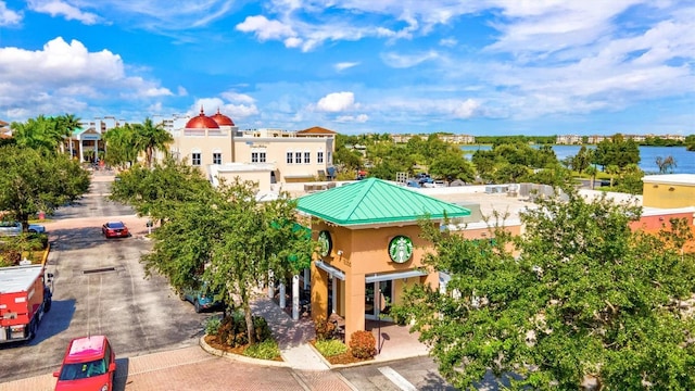 view of property's community with uncovered parking and a water view