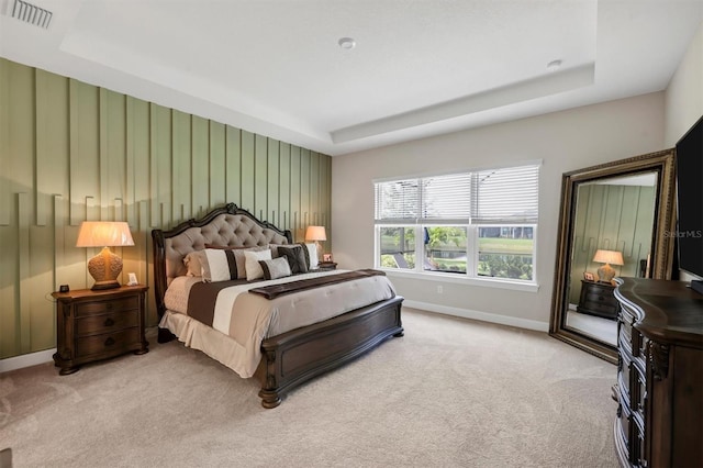 carpeted bedroom with a raised ceiling