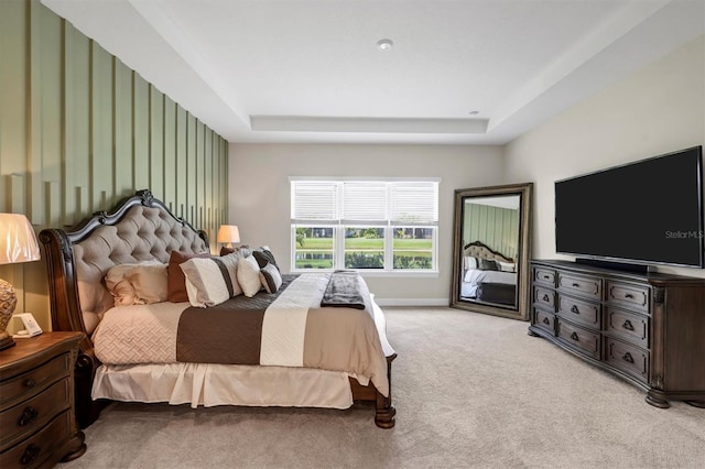 carpeted bedroom with a tray ceiling