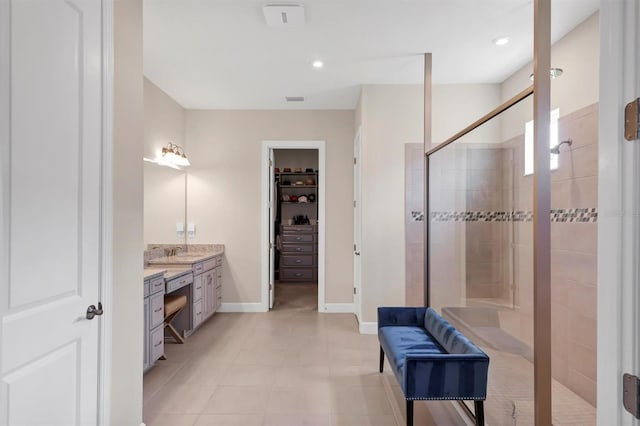 bathroom featuring a tile shower and vanity