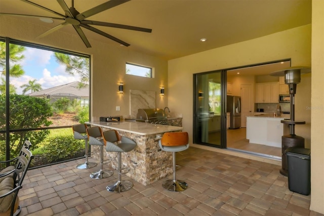 view of patio / terrace with a grill, an outdoor bar, and ceiling fan