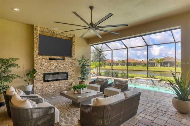 view of patio / terrace featuring pool water feature, a lanai, and an outdoor living space with a fireplace