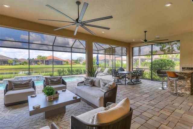 sunroom / solarium with plenty of natural light, a water view, and ceiling fan