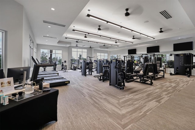 exercise room with light carpet and ceiling fan