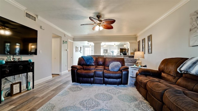 living room featuring ceiling fan, wood-type flooring, and ornamental molding